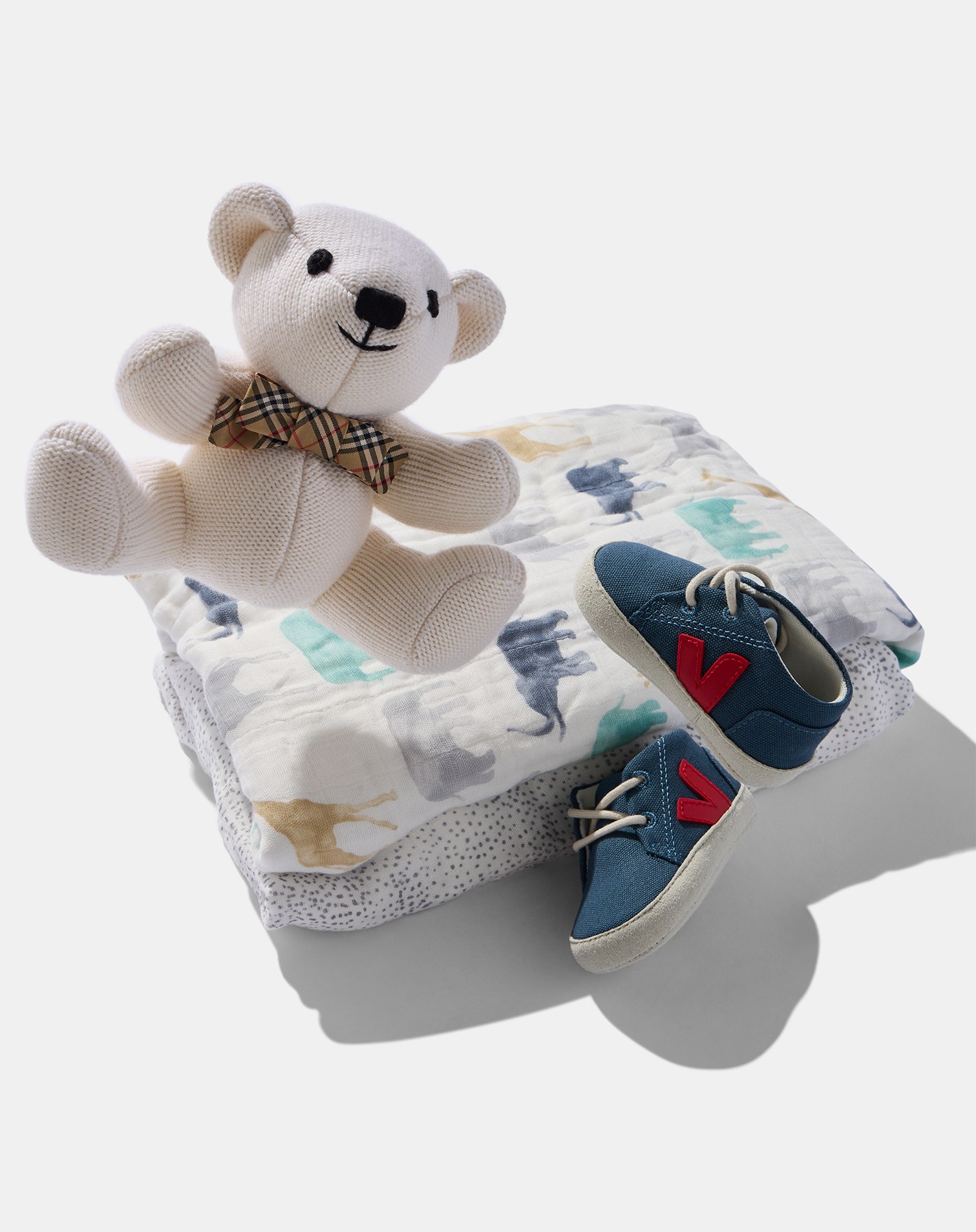 Peluche, copertina stampata e sneakers Veja