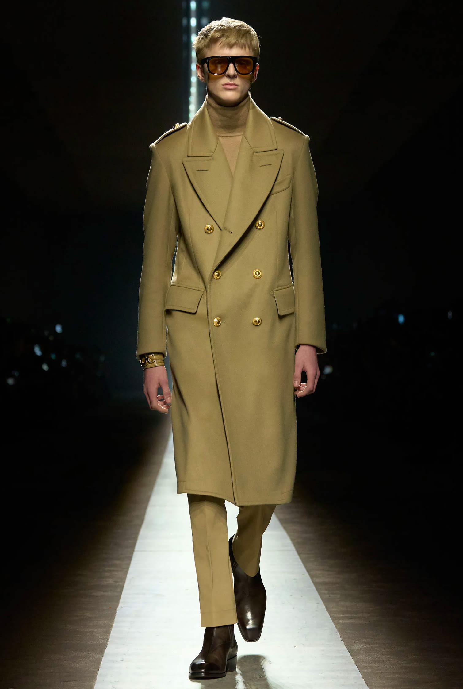 Look da passerella di Tom Ford con outfit monocromatico verde oliva con cappotto lungo e occhiali da sole