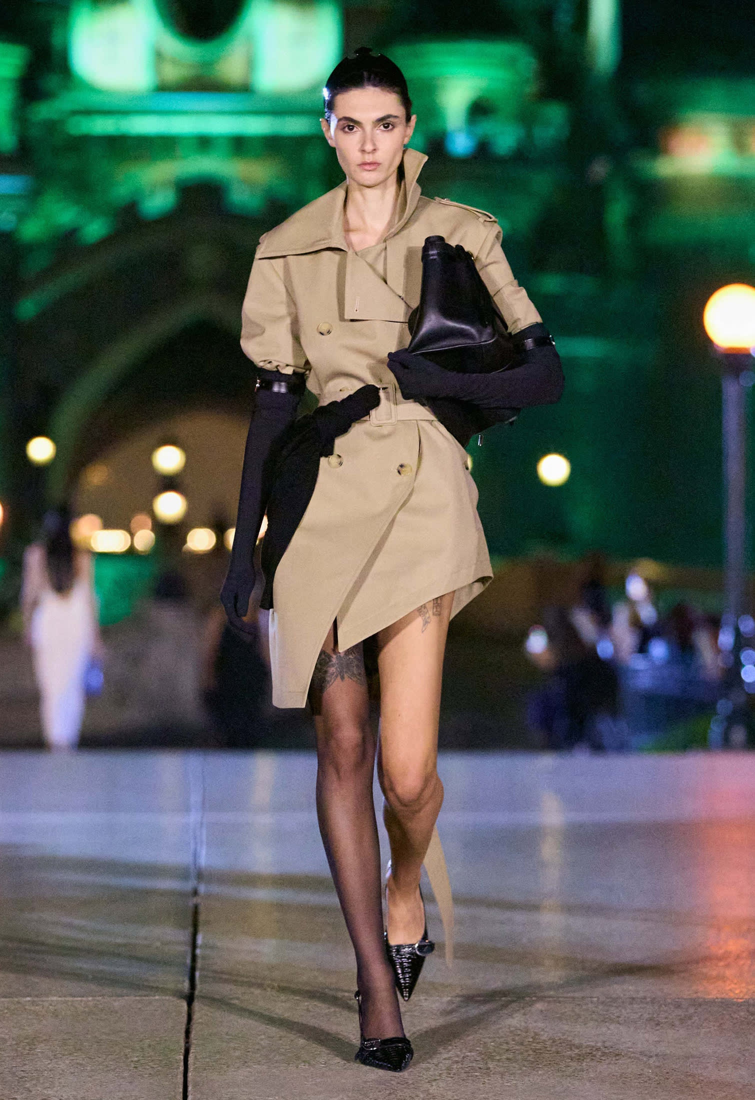 woman walking with short classic beige trench coat and black accessories