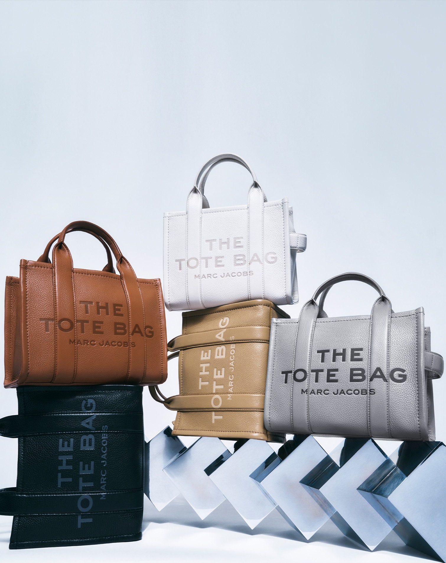 Modelli di vari colori (nero, bianco, grigio, marrone) della borsa "The Tote Bag" di Marc Jacobs